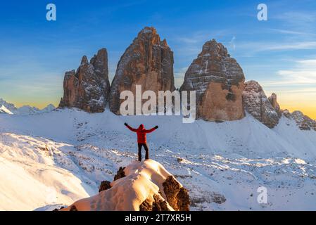 Fröhlicher Wanderer genießt den Blick auf die Tre Cime di Lavaredo bei Sonnenuntergang, Winterblick, Tre Cime di Lavaredo (Lavaredo Gipfel) Stockfoto