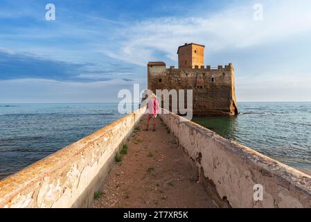 Touristen, die auf der Promenade stehen und Schloss Torre Astura, Gemeinde Nettuno, Provinz Rom, Tyrrhenisches Meer, Latium (Latium), Italien Stockfoto