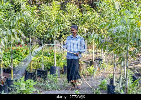 Gärtner bewässert einen der Gärten im Goverdan Ecovillage, Maharashtra, Indien, Asien Stockfoto
