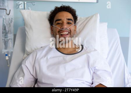 Porträt eines glücklichen männlichen Patienten im Bett im sonnigen Krankenhauszimmer Stockfoto