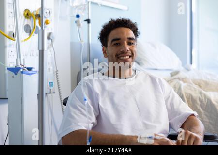 Porträt eines glücklichen männlichen Patienten im Rollstuhl im sonnigen Krankenhauszimmer Stockfoto