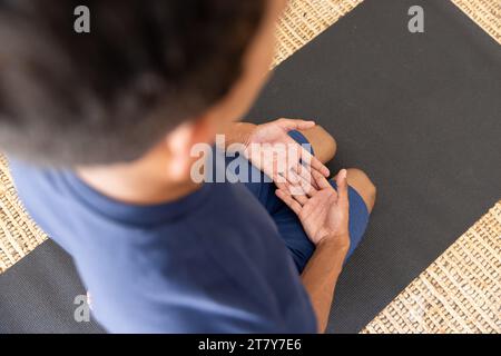 Nahaufnahme eines birassischen Mannes, der Yoga macht und zu Hause meditiert Stockfoto