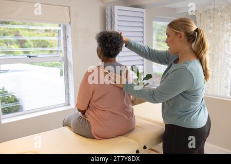 Kaukasische Physiotherapeutin behandelt ältere afrzianische amerikanische Patientin, Kopierraum Stockfoto