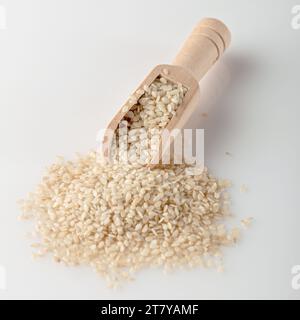 Weiße Sesamsamen liegen in einer Schaufel auf dem Tisch. Weißes Sesam zum Kochen. Kochwürze. Stockfoto
