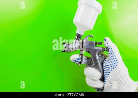 Handspritzpistole und Farbspritzpistole am Arbeitshintergrund Stockfoto