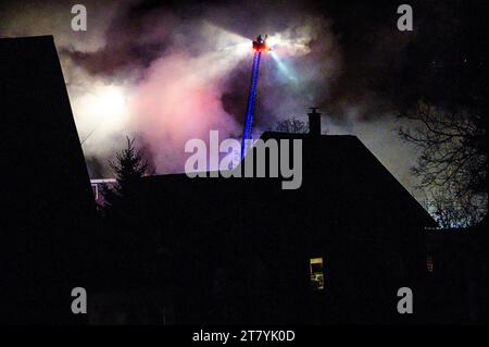 Feuerwehrmänner auf langen Leitern im Kampf gegen eine spektakuläre Blase im RK Miles Lumberyard in Montpelier, VT, New England, USA. Stockfoto