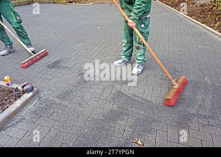 Garten-Landschaftsbau ein Garten- und Landschaftsbaubetrieb hat eine Fläche für den Bau einer Zufahrt fertiggestellt und verfugt die Pflastersteine. *** Garten Landschaftsgestaltung Ein Garten- und Landschaftsbauunternehmen hat einen Bereich für den Bau einer Auffahrt fertiggestellt und verfugt die Pflastersteine Credit: Imago/Alamy Live News Stockfoto