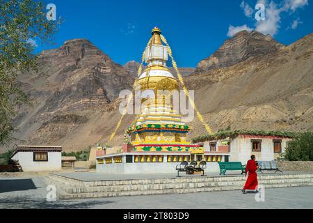 Große buddhistische Stupa mit Himalaya als Kulisse unter hellem Himmel mit einem unbekannten Mönch, der im Dorf Tabo, Himachal Pradesh, Indien, vorbeiläuft. Stockfoto