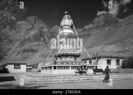 Große buddhistische Stupa mit Himalaya als Kulisse unter hellem Himmel mit einem unbekannten Mönch, der im Dorf Tabo, Himachal Pradesh, Indien, vorbeiläuft. Stockfoto