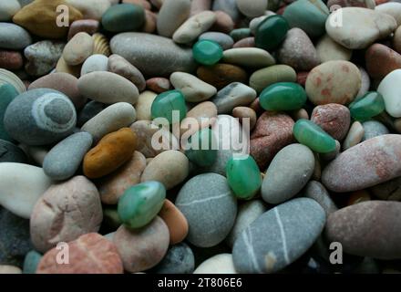 Grüne Mineralien auf Einem farbigen Kieselstein mit Quarzgängen Texturhintergrund Stockfoto