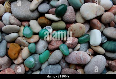 Grüne Halbedelsteine auf farbigen Kieselsteinen mit Quarzadern Texturhintergründen Stockfoto