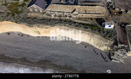 East Sussex, Großbritannien. November 2023. Das alte Birling Gap Hotel wurde abgerissen, da es zu nahe an der Klippe und dem Meer im Seven Sisters National Park in der Nähe von Eastbourne liegt. Das 1878 erbaute viktorianische Hotel hatte einst eine Sonnenlounge (die bereits am Meer verloren war) und bis vor kurzem war ein National Trust Cafe neben dem Besucherzentrum. Durch den Abriss wird das Gebäude abgerissen, und die NT hofft, ein neues Besucherzentrum im Landesinneren zu errichten, da die verbleibenden Gebäude bald von Erosion bedroht sind. Das Hotel zog einst wohlhabende Autofahrer an und hatte einen eigenen Golfplatz hinter dem Hotel. Birling Gap, East Suss Stockfoto