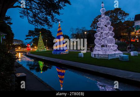 Bournemouth, Dorset, Großbritannien. November 2023. Besucher, Familien und aufgeregte Kinder besuchen Bournemouth Gardens, um das Bournemouth Christmas Tree Wonderland mit mehr als 100 glitzernden Bäumen und Lichtern zu erleben. Einige der Bäume sind thematisch für Städte auf der ganzen Welt gedacht. Bei der Eröffnung dieses Abends können Besucher dem Weg folgen und von jetzt bis zum 1. Januar durch den 60 Fuß langen Walkthrough-Baum spazieren. Quelle: Carolyn Jenkins/Alamy Live News Stockfoto