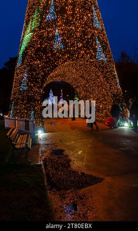 Bournemouth, Dorset, Großbritannien. November 2023. Besucher, Familien und aufgeregte Kinder besuchen Bournemouth Gardens, um das Bournemouth Christmas Tree Wonderland mit mehr als 100 glitzernden Bäumen und Lichtern zu erleben. Einige der Bäume sind thematisch für Städte auf der ganzen Welt gedacht. Bei der Eröffnung dieses Abends können Besucher dem Weg folgen und von jetzt bis zum 1. Januar durch den 60 Fuß langen Walkthrough-Baum spazieren. Quelle: Carolyn Jenkins/Alamy Live News Stockfoto