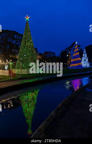 Bournemouth, Dorset, Großbritannien. November 2023. Besucher, Familien und aufgeregte Kinder besuchen Bournemouth Gardens, um das Bournemouth Christmas Tree Wonderland mit mehr als 100 glitzernden Bäumen und Lichtern zu erleben. Einige der Bäume sind thematisch für Städte auf der ganzen Welt gedacht. Bei der Eröffnung dieses Abends können Besucher dem Weg folgen und von jetzt bis zum 1. Januar durch den 60 Fuß langen Walkthrough-Baum spazieren. Quelle: Carolyn Jenkins/Alamy Live News Stockfoto