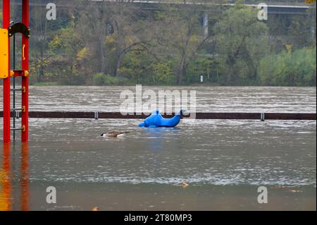 Ein hüpfender Sitz auf einem Spielzeug in Form eines Fisches oder Delfins auf einem Spielplatz ist nach Überflutung aufgrund sintflutartiger Regenfälle kaum zu sehen. Stockfoto