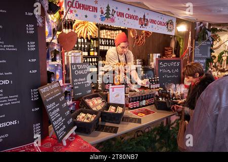 Der Verkäufer verkauft einen heißen Glühwein auf dem Weihnachtsmarkt in Colmar, Elsass, Frankreich Stockfoto