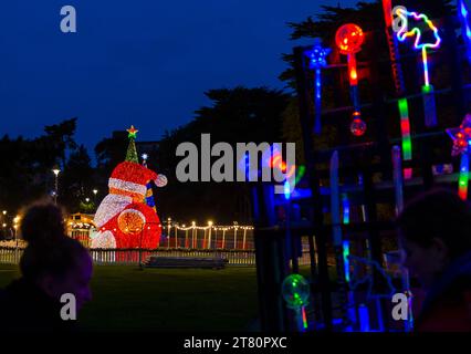 Bournemouth, Dorset, Großbritannien. November 2023. Besucher, Familien und aufgeregte Kinder besuchen Bournemouth Gardens, um das Bournemouth Christmas Tree Wonderland mit mehr als 100 glitzernden Bäumen und Lichtern zu erleben. Einige der Bäume sind thematisch für Städte auf der ganzen Welt gedacht. Bei der Eröffnung dieses Abends können Besucher dem Weg folgen und von jetzt bis zum 1. Januar durch den 60 Fuß langen Walkthrough-Baum spazieren. Quelle: Carolyn Jenkins/Alamy Live News Stockfoto