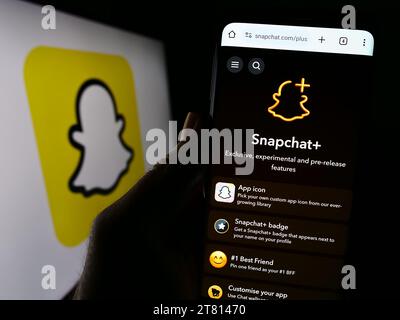 Person, die ein Mobiltelefon hält, mit Webseite der US-Multimedia-Instant-Messaging-App Snapchat vor dem Logo. Konzentrieren Sie sich auf die Mitte des Telefondisplays. Stockfoto