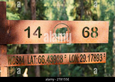 Ein Metallschild auf einem Wanderweg zeigt die Lat and Long auf dem Bear Trail in Nordfinnland Stockfoto