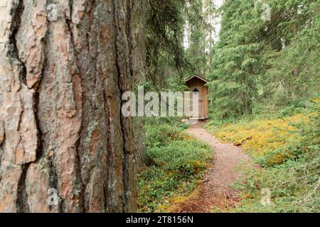 Eine kleine hölzerne Toilette mit einem Weg, der zu ihr führt, an einer Raststätte auf einem Wanderweg im Norden Finnlands Stockfoto