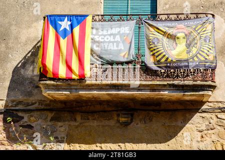 Katalanische estelada inoffizielle Sternenflagge und Banner, die katalanische Unabhängigkeit fördern, hängen von einem Balkon im Dorf Pals, Katalonien, Spanien Stockfoto