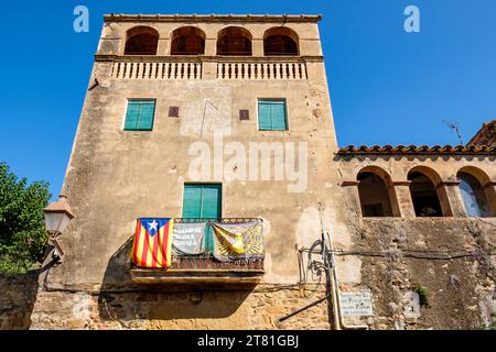 Katalanische estelada inoffizielle Sternenflagge und Banner, die katalanische Unabhängigkeit fördern, hängen von einem Balkon im Dorf Pals, Katalonien, Spanien Stockfoto