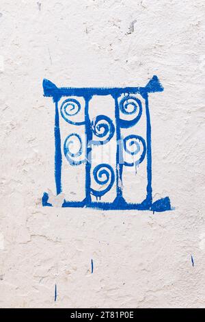 Kairouan, Tunesien. Kunstwerk eines blauen Gitterfensters auf einer weißen Stuckwand. Stockfoto