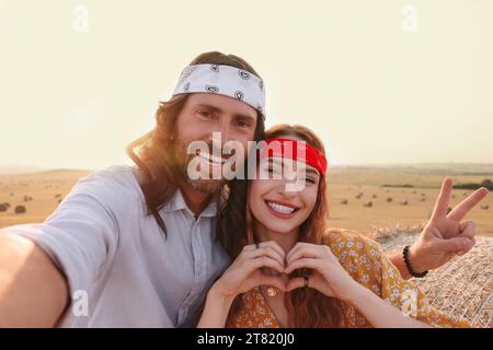 Glückliches Hippie-Paar, das Selfie im Feld macht Stockfoto