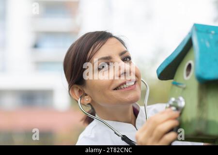Der Arzt untersucht den Zustand der Nistbox mit einem Stethoskop-Umweltschutz Stockfoto