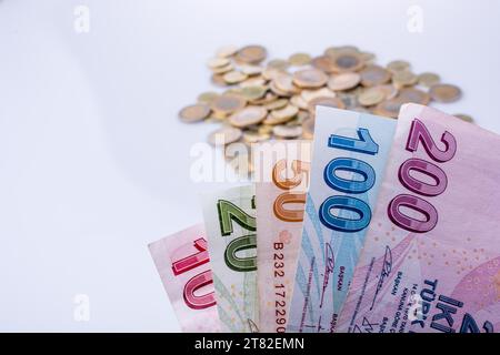 Türkische Lira-Münzen und-Banknoten nebeneinander auf weißem Hintergrund Stockfoto