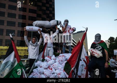 Los Angeles, Usa. November 2023. Pro-palästinensische Demonstranten halten während der Demonstration gefälschte Leichen Taschen mit Kindern. Demonstranten, angeführt von der palästinensischen Jugendbewegung, versammelten sich vor dem israelischen Generalkonsulat in Los Angeles, um gegen die anhaltende Belagerung des Gazastreifens durch Israel und die humanitäre Krise zu protestieren, die sie verursacht. (Foto: Adam Delgiudice/SOPA Images/SIPA USA) Credit: SIPA USA/Alamy Live News Stockfoto