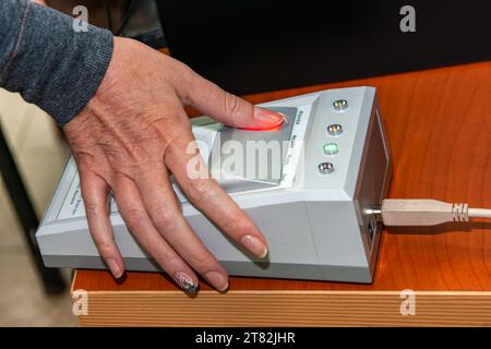 Biometrischer Fingerabdruck, Frau, die den Scanner benutzt Stockfoto