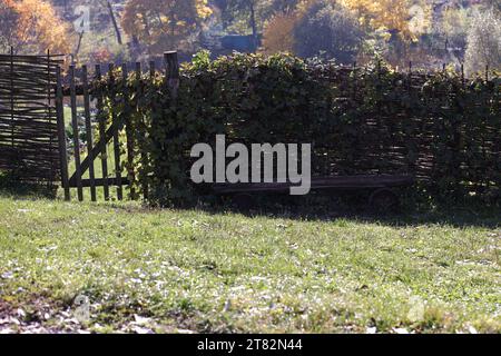 Horizontaler Flechtzaun mit Wickeln und Holzbank in der Nähe von Sommertagen in Yasnaja Polyana, Russland Stockfoto