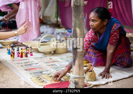 Bolpur, Westbengalen, Indien - 22. Oktober 2023: Eine Frau aus einem Stammesdorf, die in einem Straßenladen Kunsthandwerk verkauft Stockfoto