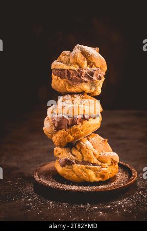 Profiteroles oder Creme Puff gefüllt mit Schokoladencreme, französischer Choux Gebäck Ball Stockfoto