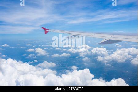 Luftaufnahme über den Wolken. Blick auf den Himmel und das blaue Meer vom Flugzeug aus. Stockfoto