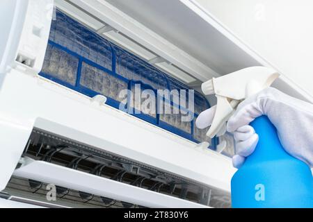 Reinigen des verschmutzten Luftfilters in den Klimaanlagen. Mit Wassersprühflasche Stockfoto