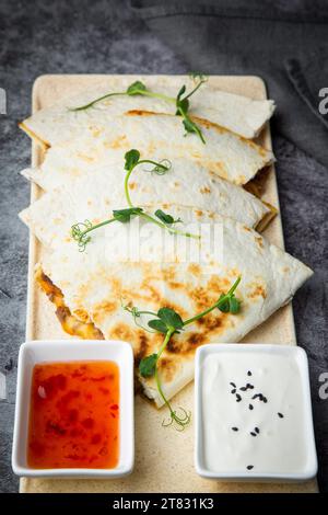 Huhn Quesadilla mit Kräutersoße und Sauerrahm, Seitenansicht Stockfoto