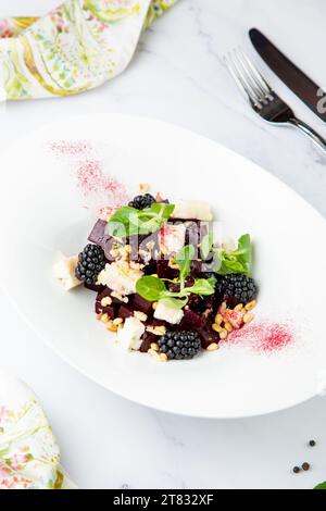 Salat aus Brombeeren, Rüben, Samen und Käse, Seitenansicht auf einem weißen Teller Stockfoto