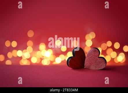 Zwei rote Valentinsholz-Herzen auf rotem Hintergrund. Stockfoto