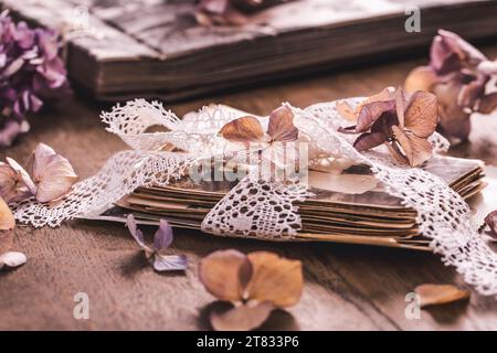 Erinnerungen, antike und alte Familienfotos mit getrockneten Blumen im Vintage-Stil auf Holztisch Stockfoto