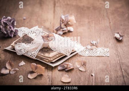 Erinnerungen, antike und alte Familienfotos mit getrockneten Blumen im Vintage-Stil auf Holztisch Stockfoto