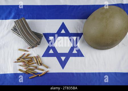 Munition aus der Waffe. Kugeln und Zeitschriften. Militärhelm. Armeekonzept. Israelische Flagge als Hintergrund. Stockfoto