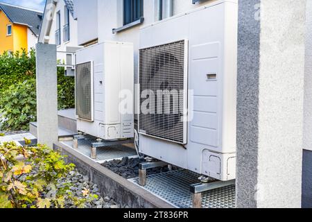 Zwei Luftquellenwärmepumpen außerhalb des modernen Familienhauses installiert, Konzept der Wärmepumpe für umweltfreundliche erneuerbare Energien Stockfoto