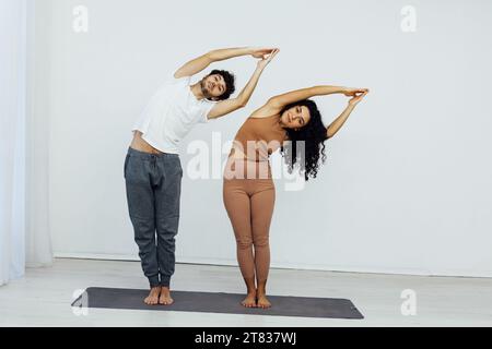 Eine Frau und ein Mann machen Gymnastik-Aufwärmübungen Yoga-Asana-Posen Stockfoto