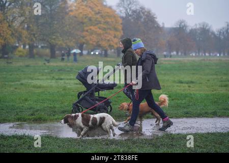 Wimbledon, London, Großbritannien. 18. November 2023. Die Leute gehen heute Morgen mit ihren Hunden auf einem wasserdurchnässten Wimbledon Common, da mehr Regen erwartet wird, um die Hauptstadt zu treffen. Das Met Office hat weitere Wetterwarnungen für weitere Atlantikstürme veröffentlicht, die Großbritannien mit starken Winden, starkem Regen und Überschwemmungen für das Wochenende treffen. Quelle: amer Gazzal/Alamy Live News Stockfoto