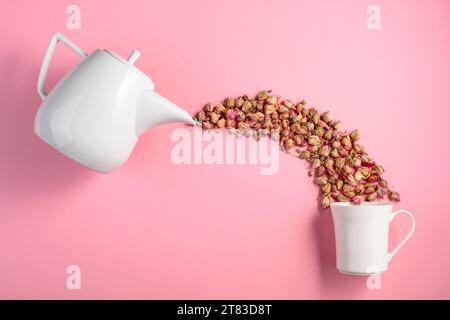 Getrocknete Rosenknospen auf pinkfarbenem Hintergrund. Konzeptbild zum Thema pflanzliche Medizin. Draufsicht mit Kopierbereich. Stockfoto