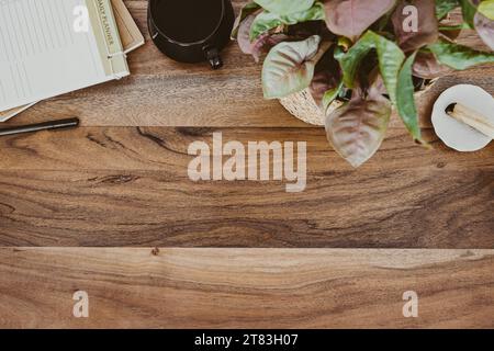 Holzschreibtisch Büro Kopierraum mit Notizblöcken, Tasse Tee, Zimmerpflanze und palo santo Flat Lay. Draufsicht. Kopierbereich. Modernes ästhetisches Arbeitsplatzkonzept. Stockfoto