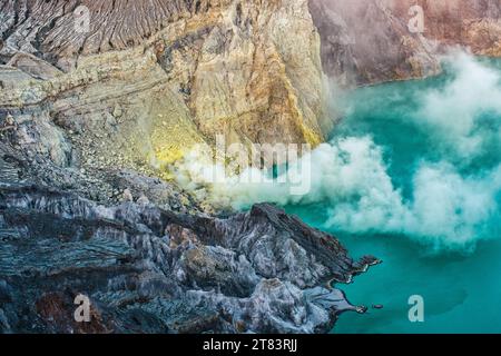 Aktiver Vulkan mit schwebendem Schwefelrauch und türkisfarbenem See in Kawah Ijen, Indonesien Stockfoto